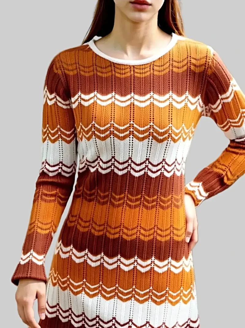 Elegante gebreide jurk met opengewerkt patroon, lange mouwen en lichte stretch.
