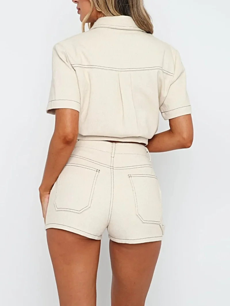 Stijlvolle tweedelige denimset bestaande uit een top met korte mouwen en knoopsluiting en een getailleerde short.