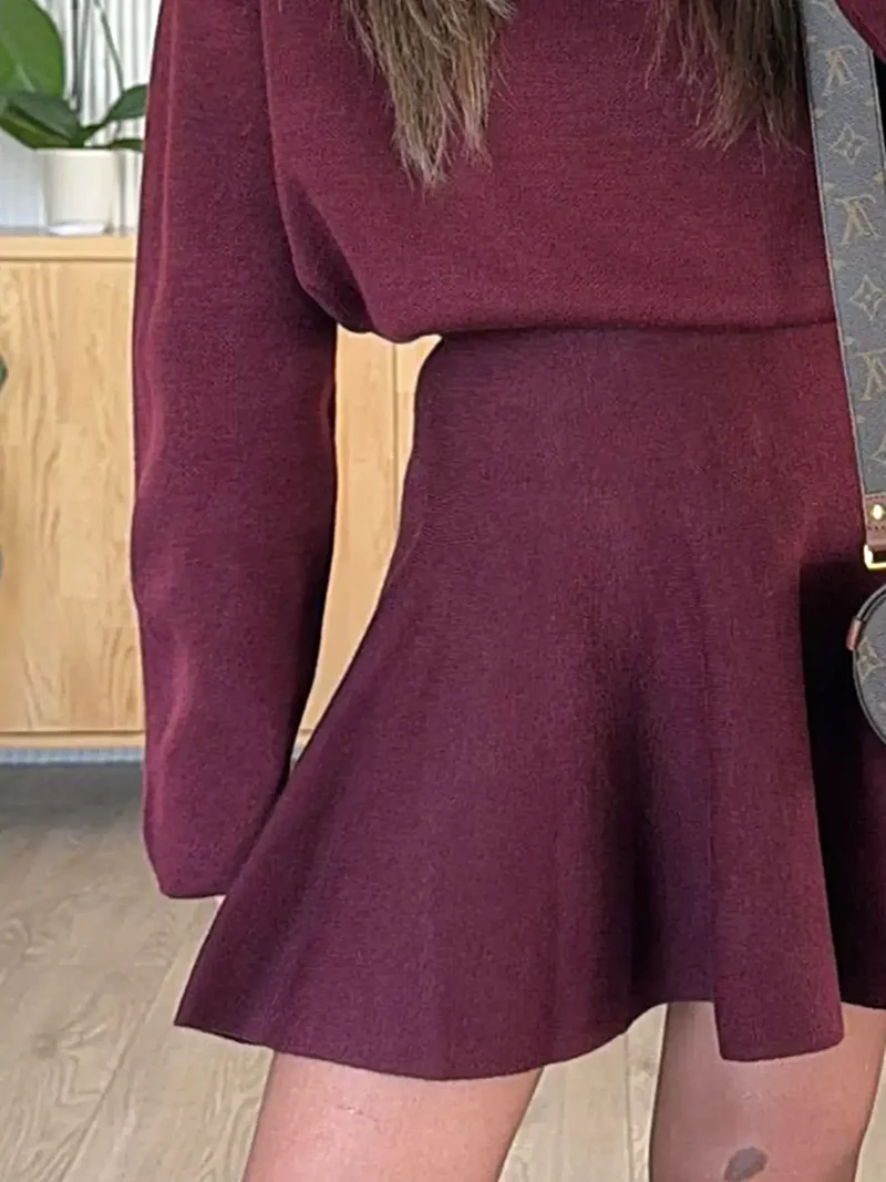 Elegante damesminijurk met ronde hals en lange mouwen, gemaakt van zachte, elastische gebreide stof.