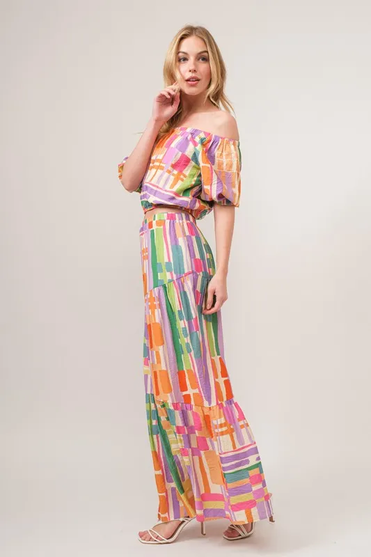 En de reden voor de asymmetrische maxi-rok met geometrische print en meerdere lagen