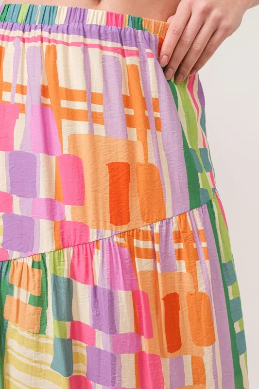 En de reden voor de asymmetrische maxi-rok met geometrische print en meerdere lagen