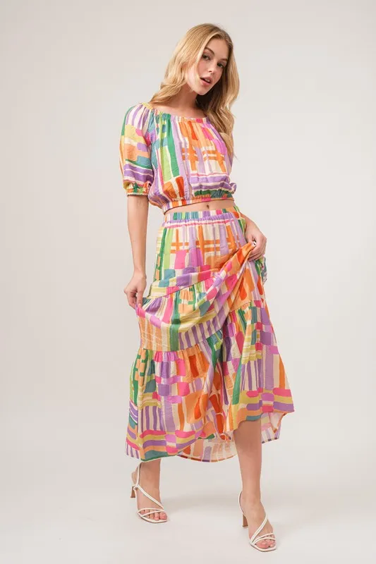 En de reden voor de asymmetrische maxi-rok met geometrische print en meerdere lagen