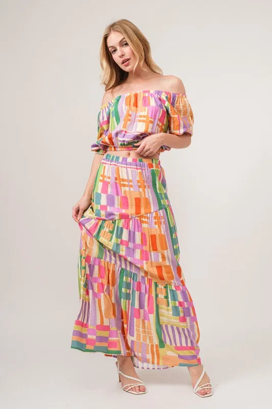 En de reden voor de asymmetrische maxi-rok met geometrische print en meerdere lagen