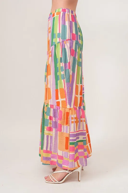 En de reden voor de asymmetrische maxi-rok met geometrische print en meerdere lagen