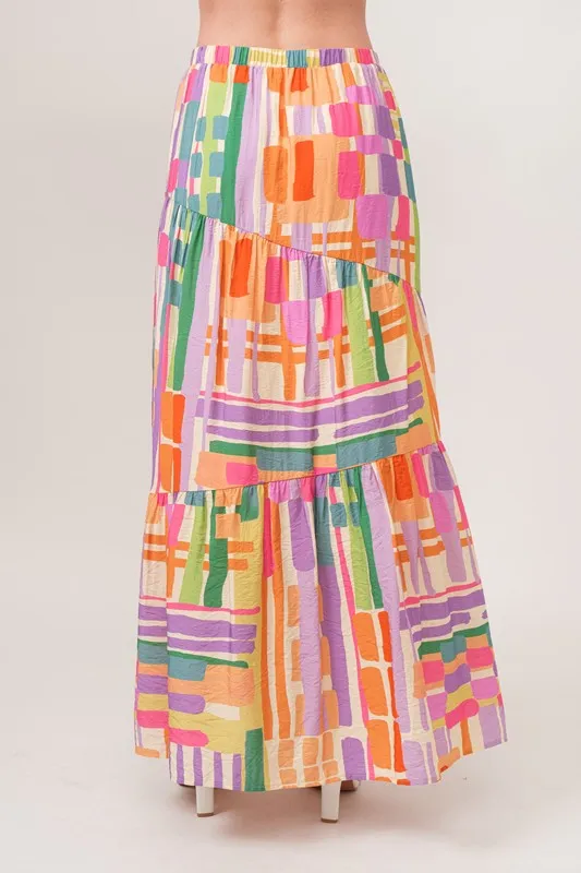 En de reden voor de asymmetrische maxi-rok met geometrische print en meerdere lagen