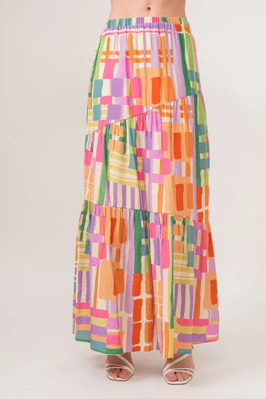 En de reden voor de asymmetrische maxi-rok met geometrische print en meerdere lagen