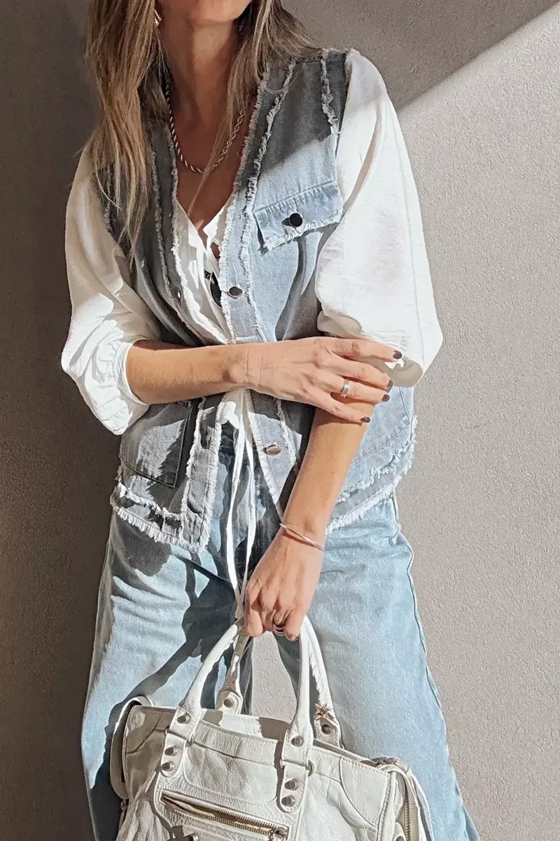 Chique denimvest met gerafelde randen, klepzakken, onafgewerkte zoom en knoopsluiting aan de voorkant.