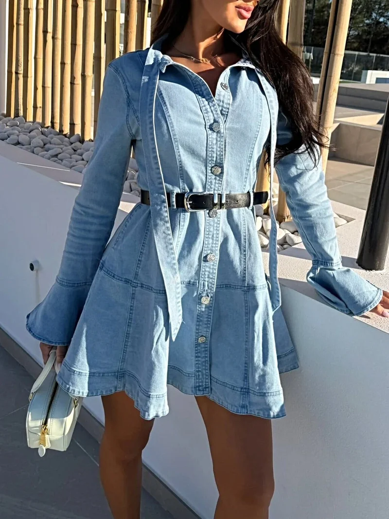 Stijlvolle denimjurk met ruchesmouwen, knoopsluiting aan de voorkant en strik- en ceintuur.