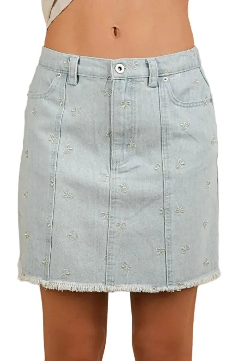 Charmante denim minirok met strikprint, rafelige zoom en zakken voor een casual, elegante look.