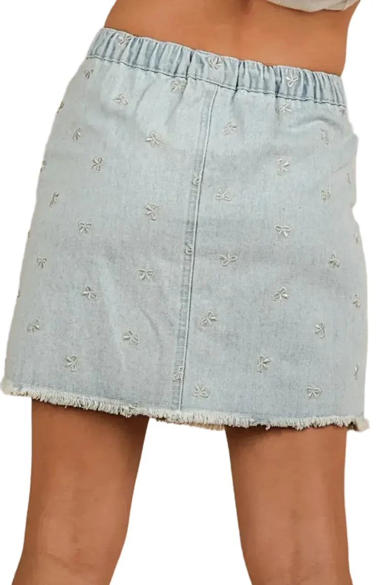 Charmante denim minirok met strikprint, rafelige zoom en zakken voor een casual, elegante look.