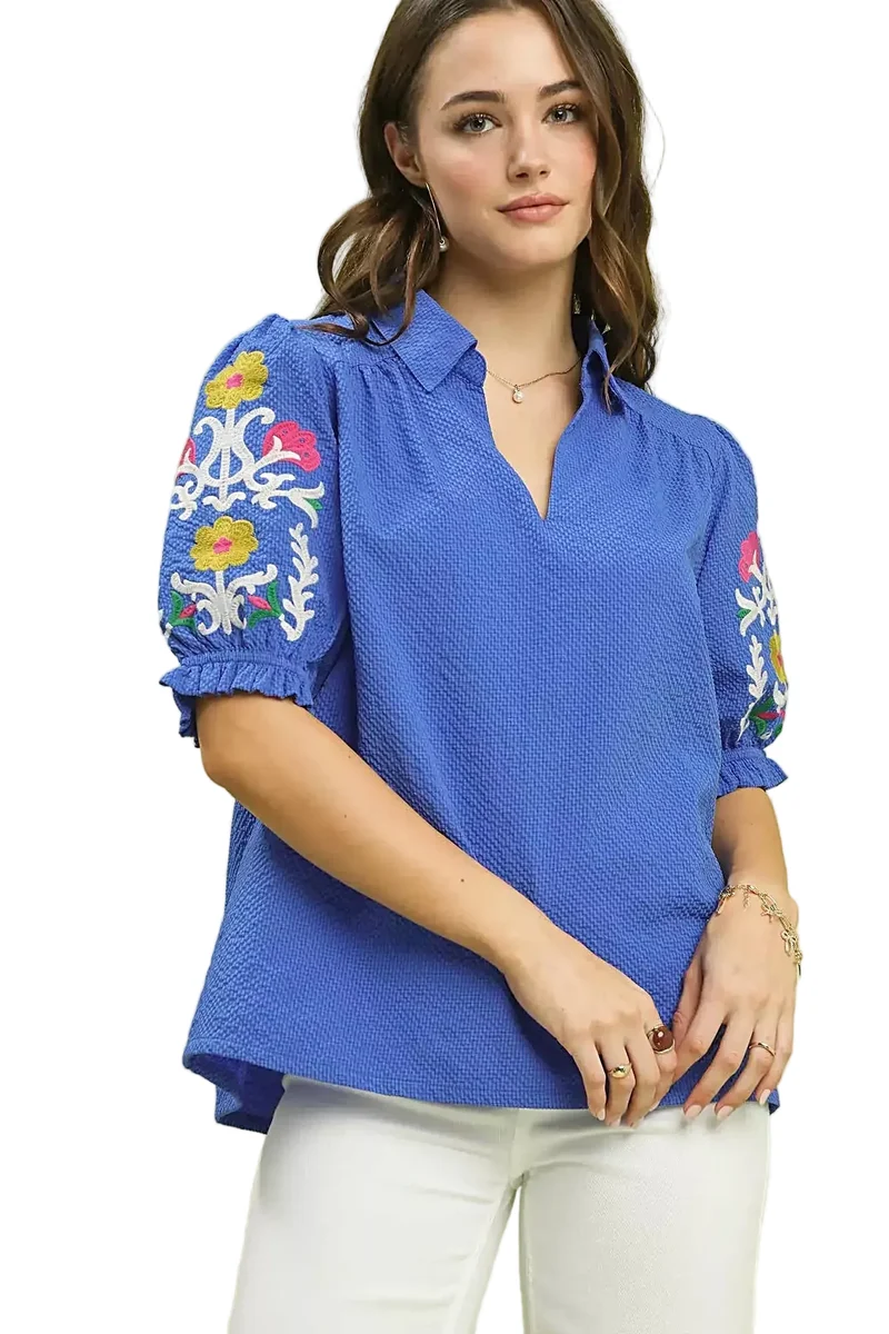 Elegante top van 100% polyester seersucker met geborduurde mouwen en een verfijnde open kraag.