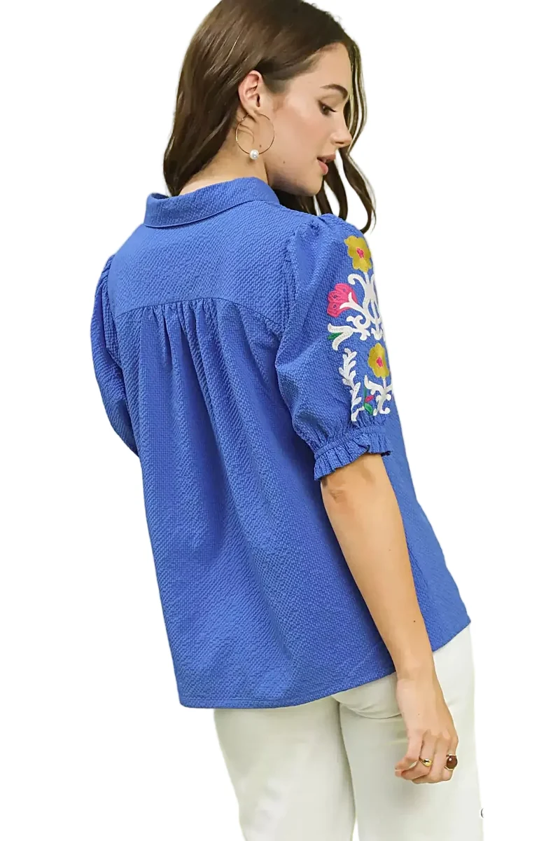 Elegante top van 100% polyester seersucker met geborduurde mouwen en een verfijnde open kraag.