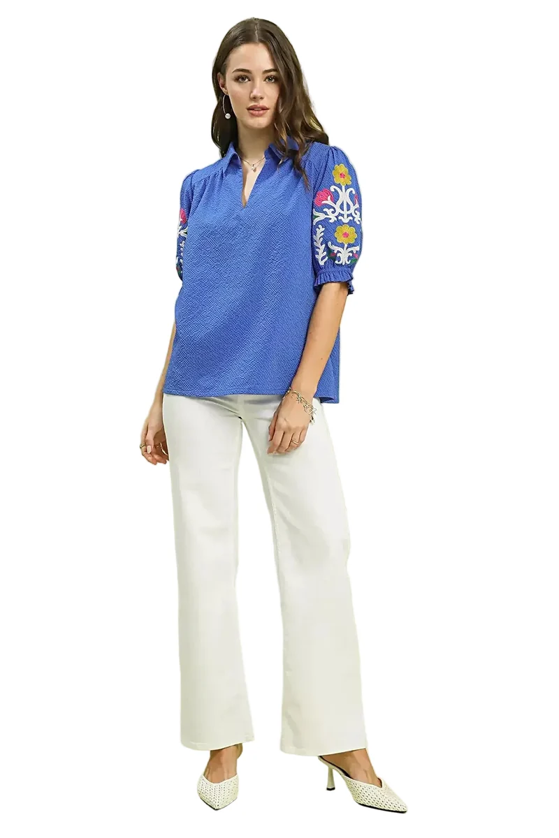 Elegante top van 100% polyester seersucker met geborduurde mouwen en een verfijnde open kraag.