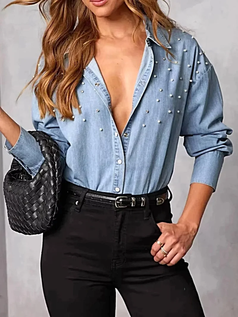 Elegant denim overhemd met parelversiering en knoopsluiting – een tijdloze modeklassieker.
