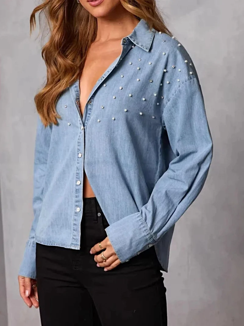 Elegant denim overhemd met parelversiering en knoopsluiting – een tijdloze modeklassieker.