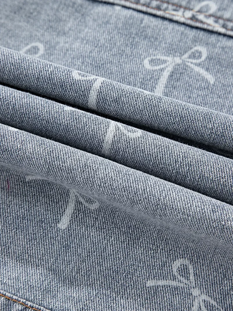 Lichtblauwe denim jas met strikprint en rafelige zoom, met zakken met knoopsluiting.