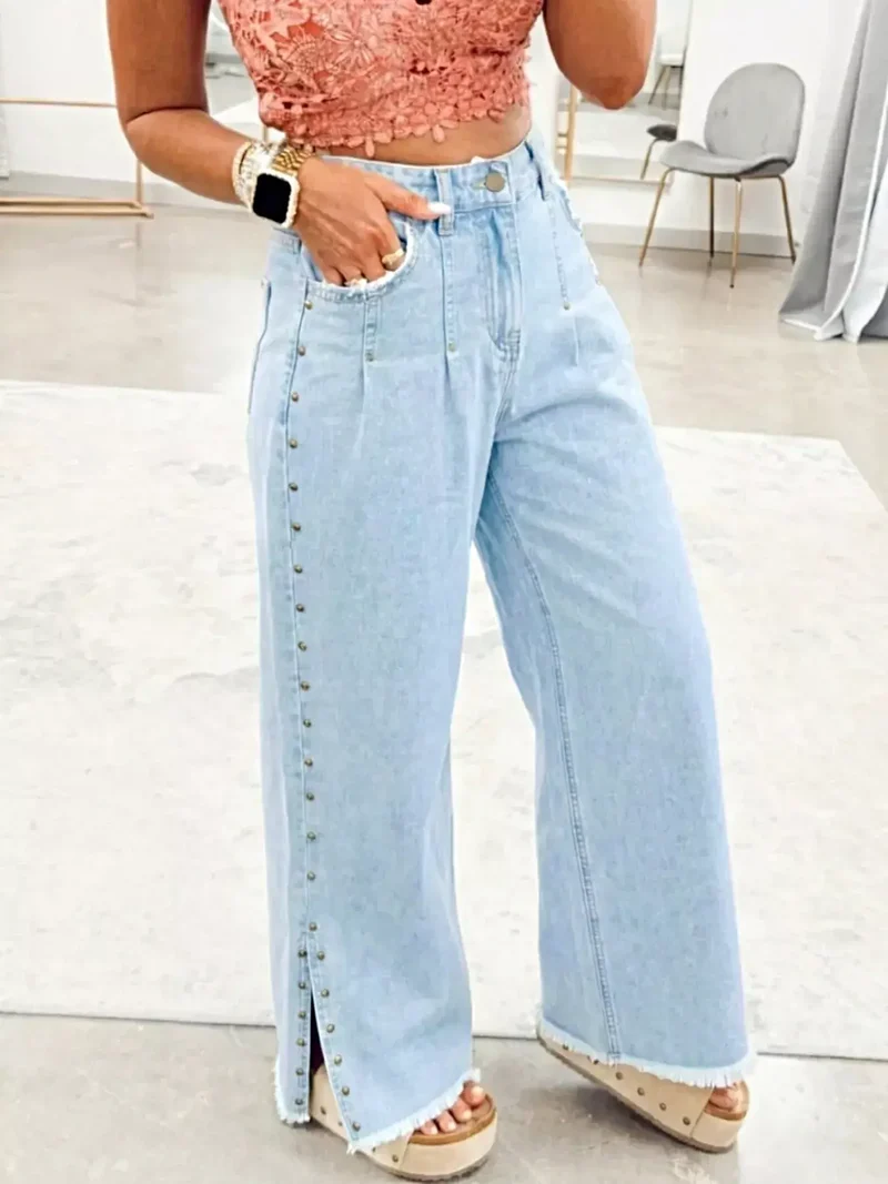 Luxe jeans met studs, zijsplitten, gerafelde zoom en wijde pijpen met zakken.