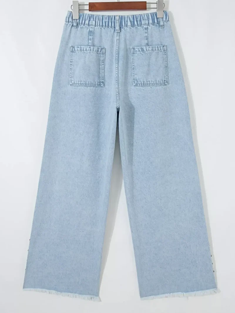 Luxe jeans met studs, zijsplitten, gerafelde zoom en wijde pijpen met zakken.