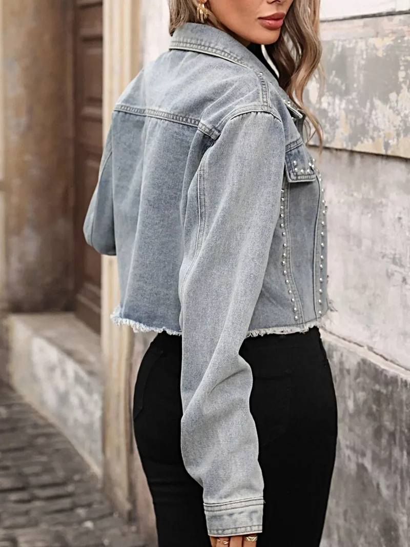 Stijlvol spijkerjack met studs en rafelige zoom - een trendsettend mode-item.