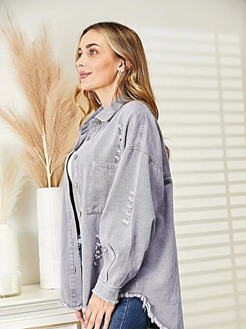 Gescheurde denimjas met rafelige zoom, knoopsluiting en relaxte pasvorm.