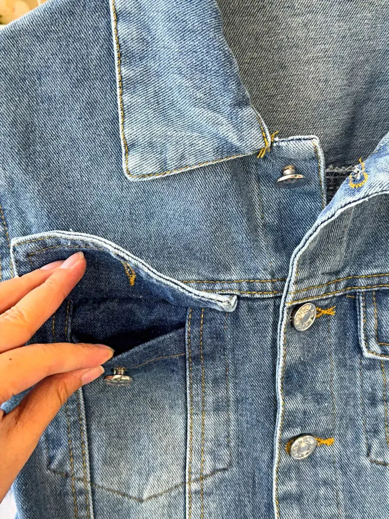 Stijlvolle denim jumpsuit met knoopsluiting aan de voorkant, zakken en een klassieke wijde pijp.