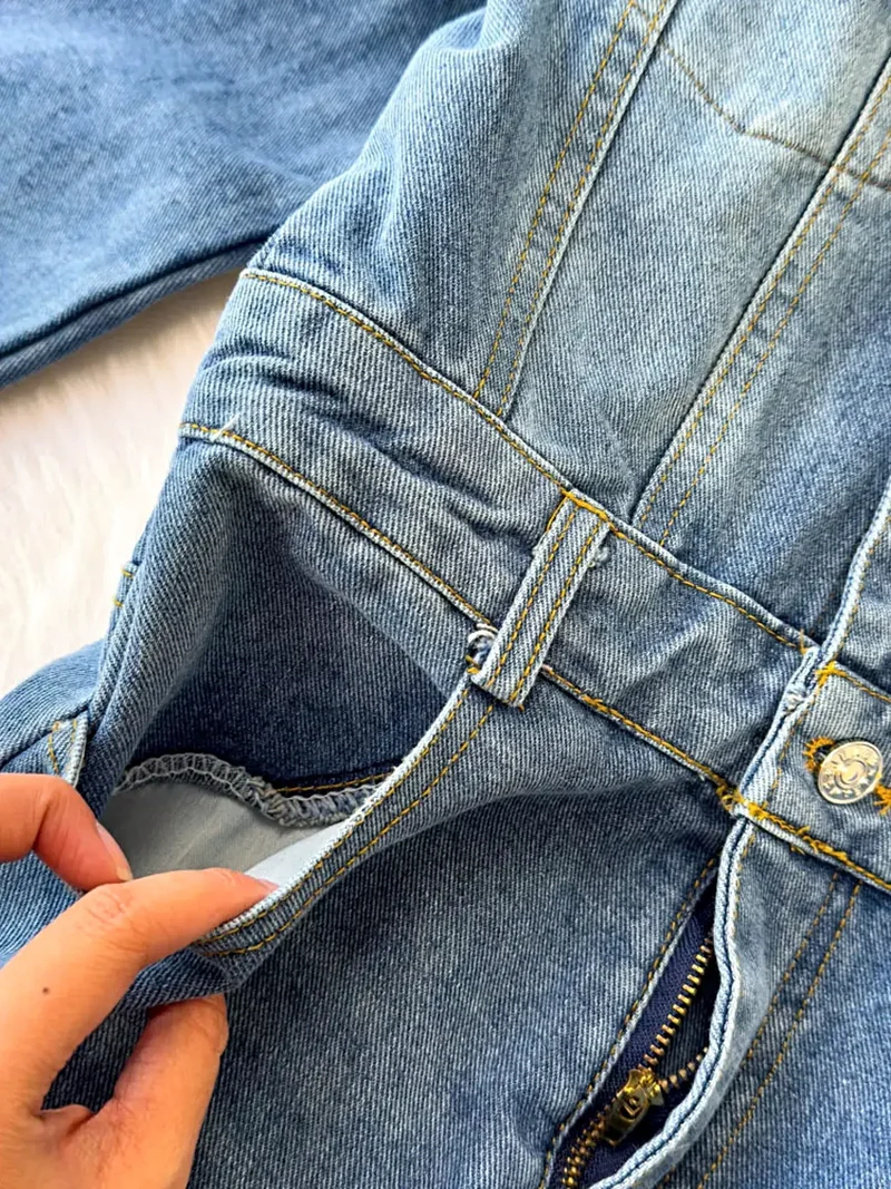 Stijlvolle denim jumpsuit met knoopsluiting aan de voorkant, zakken en een klassieke wijde pijp.