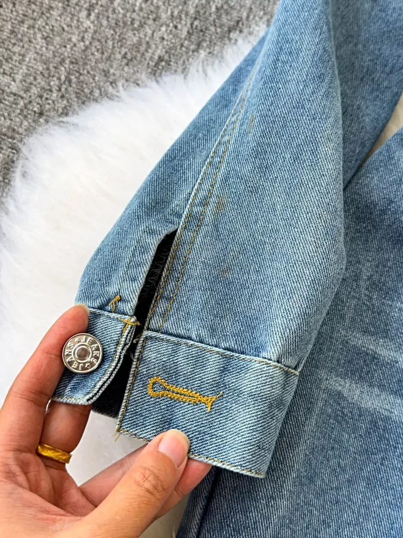 Stijlvolle denim jumpsuit met knoopsluiting aan de voorkant, zakken en een klassieke wijde pijp.
