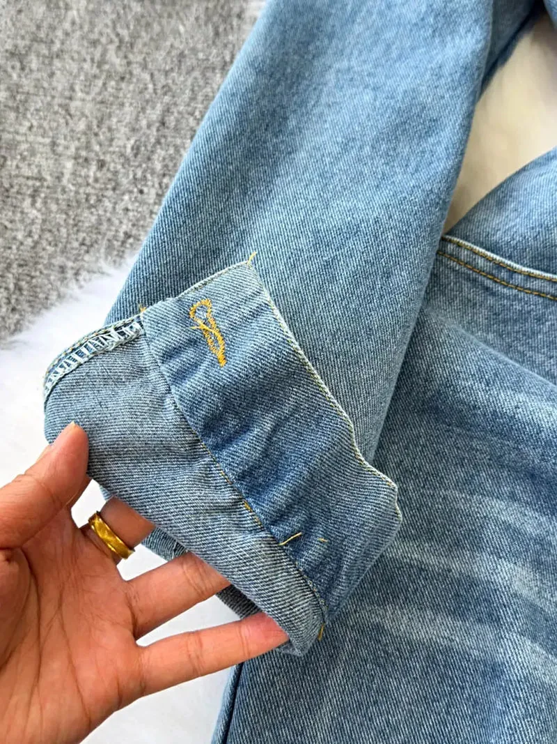 Stijlvolle denim jumpsuit met knoopsluiting aan de voorkant, zakken en een klassieke wijde pijp.