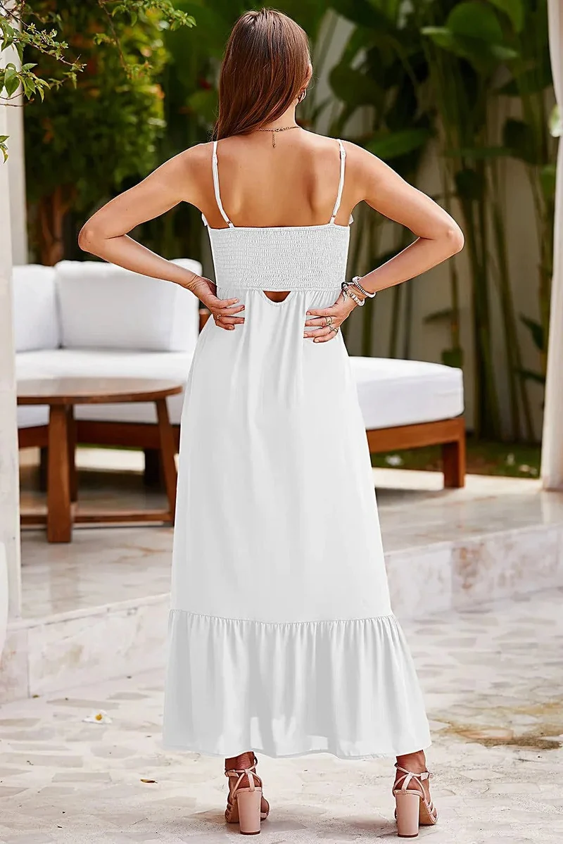 Elegante zomerjurk met spaghettibandjes, ruches aan de zoom en decoratieve knoopjes, met smockwerk.