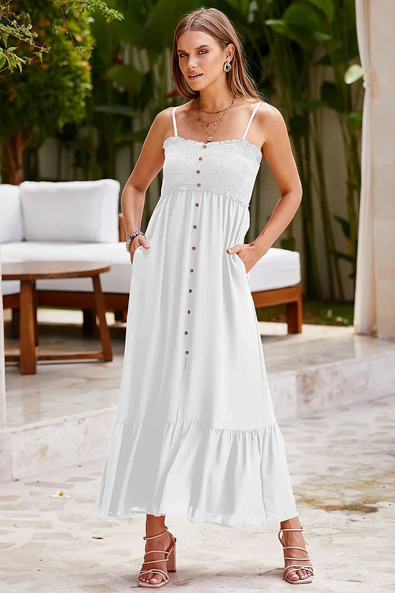 Elegante zomerjurk met spaghettibandjes, ruches aan de zoom en decoratieve knoopjes, met smockwerk.