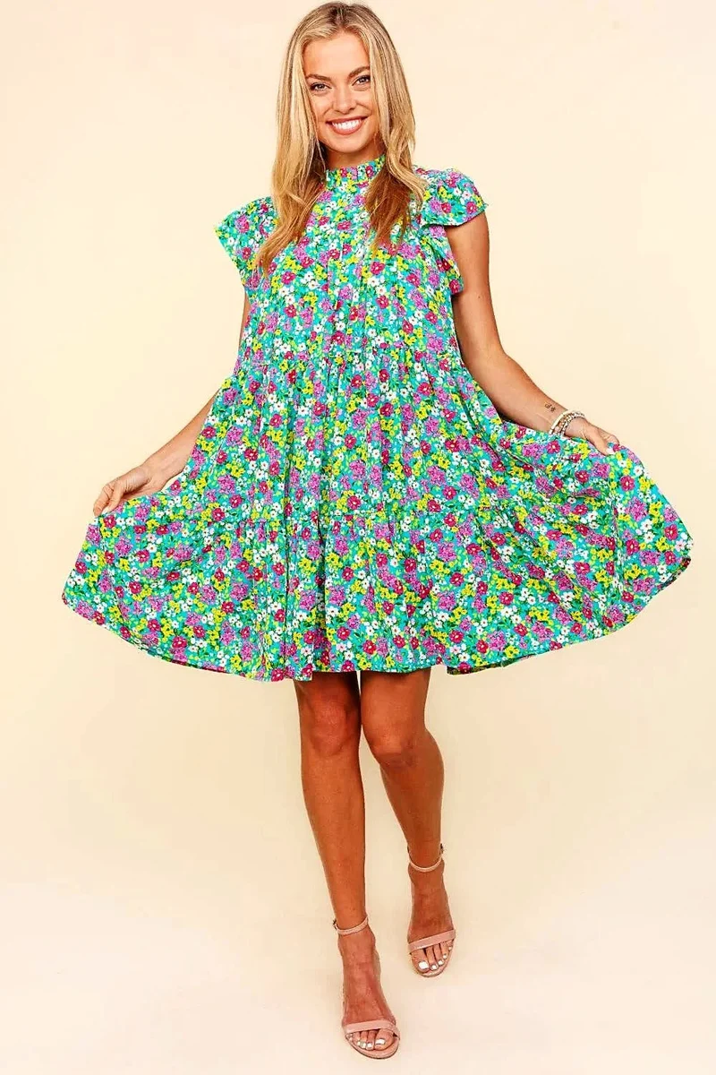 Elegante jurk met bloemenprint, colkraag, ruchesmouwen en gelaagd design.