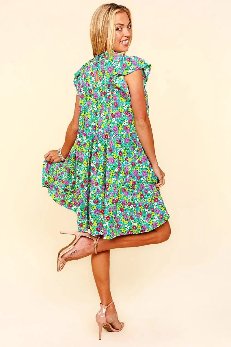 Elegante jurk met bloemenprint, colkraag, ruchesmouwen en gelaagd design.