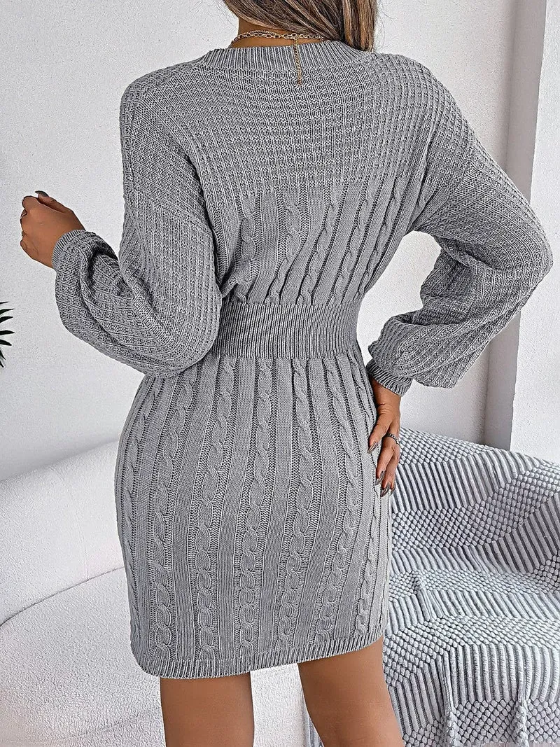 Luxe kabelgebreide sweaterjurk met uitgesneden design, ronde hals en split.