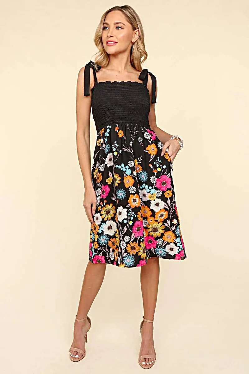 Zomerjurk met bloemenprint, geplooide camisole top en zwierig silhouet.