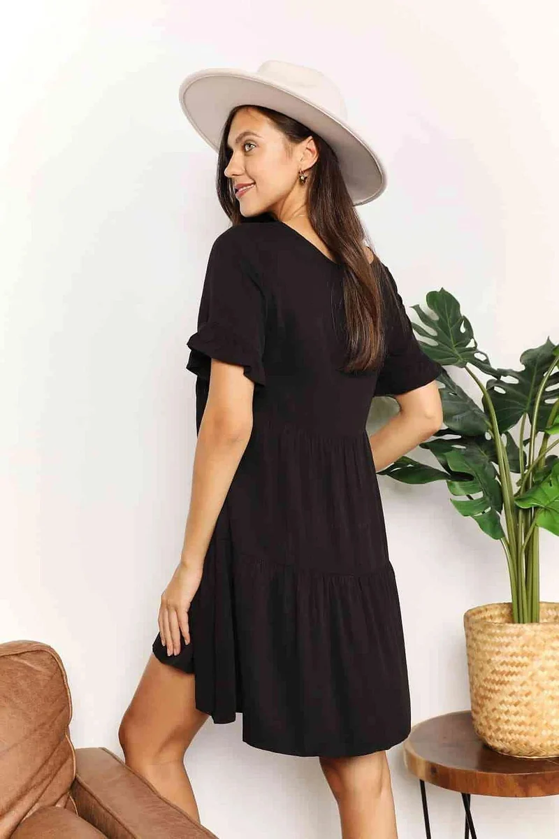 Elegante jurk met V-hals, ruches, gelaagd design en speelse mouwen voor een chique, casual look.