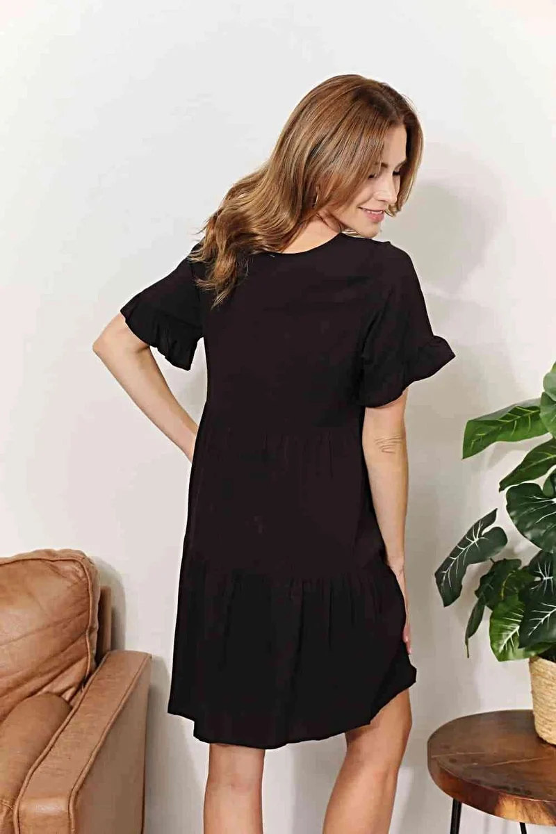 Elegante jurk met V-hals, ruches, gelaagd design en speelse mouwen voor een chique, casual look.