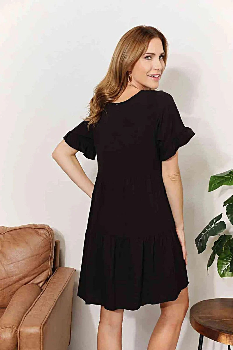 Elegante jurk met V-hals, ruches, gelaagd design en speelse mouwen voor een chique, casual look.