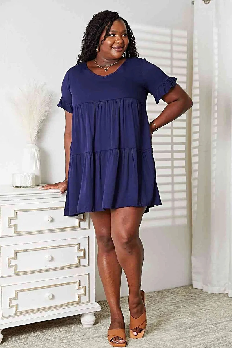 Elegante jurk met V-hals, ruches, gelaagd design en speelse mouwen voor een chique, casual look.