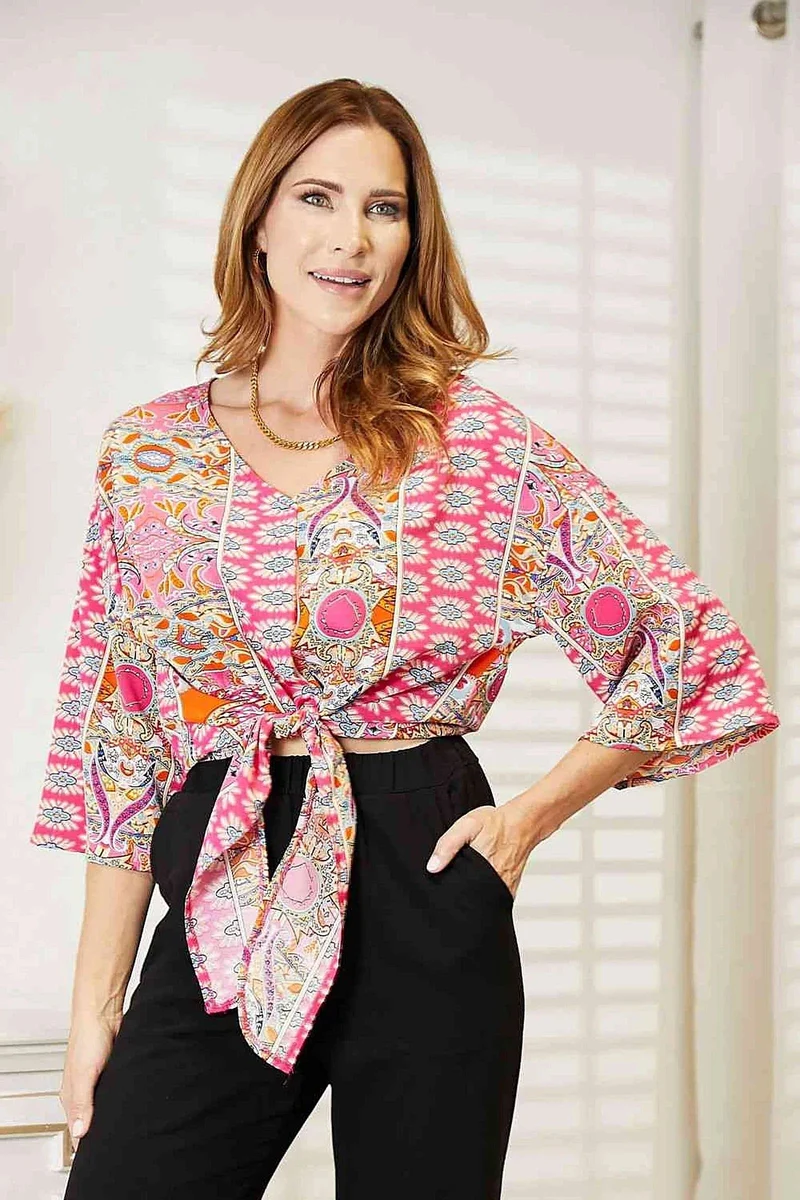 Chique blouse met driekwartmouwen, V-hals en strikdetail aan de zoom.