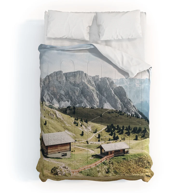 Dolomites Italy I Wooden chalets on the Seceda alpine meadow in the mountain of the Italian Alps Comforter